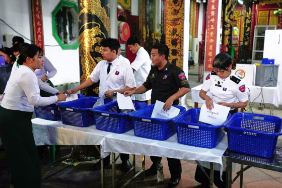 People look at documents inside of blue baskets on a table