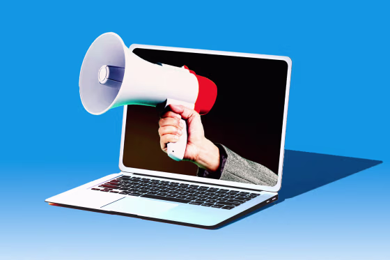 Photo illustration of hand holding a megaphone out of a laptop 
