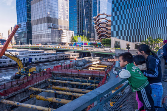 A woman and two kids overlook a a construction site in Manhattan.