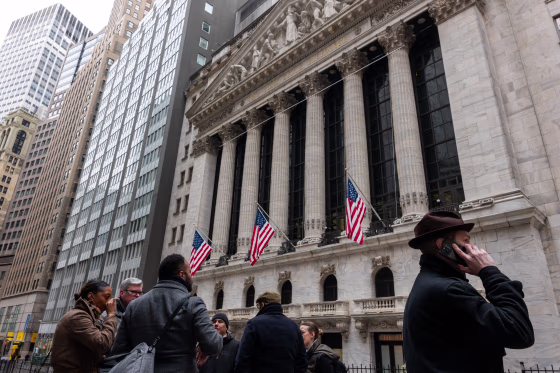 People walk outside of the  New York Stock Exchange on March 19, 2026.