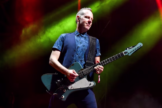 Tom Dumont plays guitar on stage