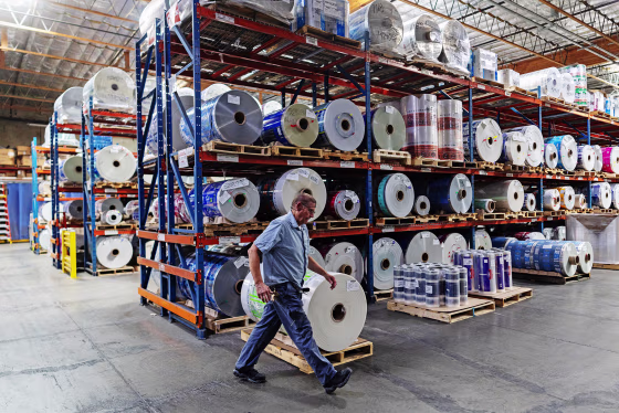 An employee at Emerald Packaging walks by rolls of plastic at the company’s facility in Union City