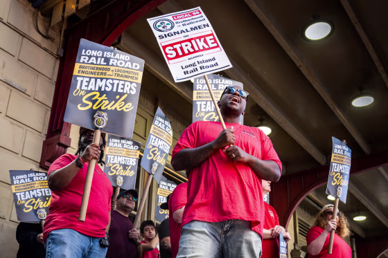Olivier Desinor leads striking workers in chants during a picket outside