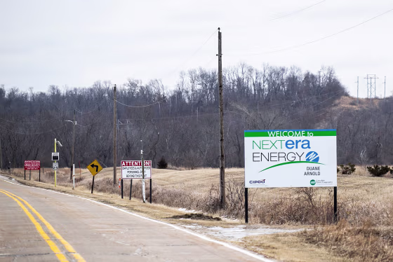 A sign for NextEra energy is seen outside along the side of a road