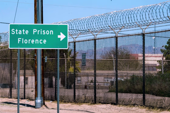A sign points in the direction of the Arizona State Prison.