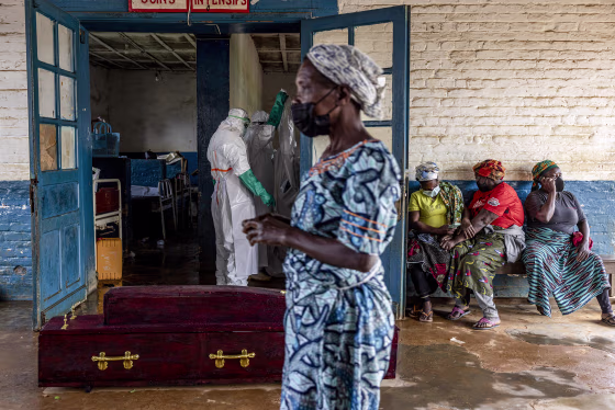 Relatives of Ebola victims sit outside the General Referral Hospital.