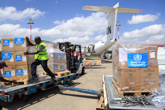 Workers load World Health Organization emergency supplies onto a United Nations plane