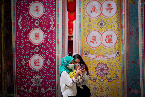 Two girls look at a mobile phone in downtown Kuala Lumpur, Malaysia, in 2021.