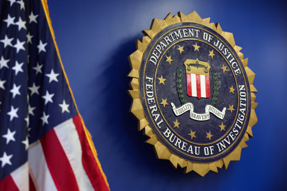 The logo of the Federal Bureau of Investigation hung on a blue wall next to an American flag