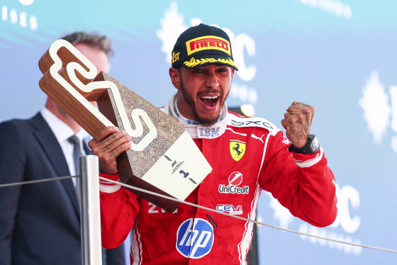 Lewis Hamilton celebrates on the podium with his trophy