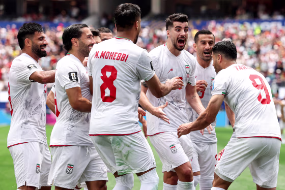 Iranian team members celebrate in a huddle