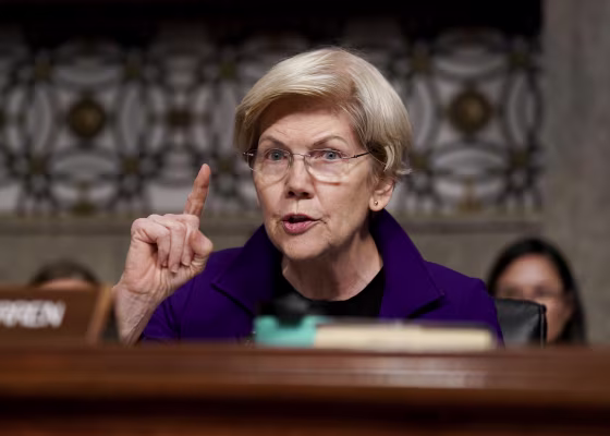 Elizabeth Warren holds one finger up while speaking during a Senate hearing.
