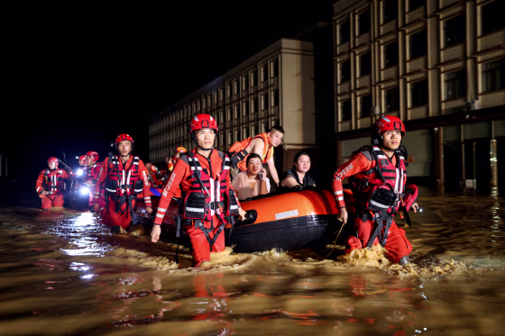 Rescue workers carry an inflatable boat with victims.