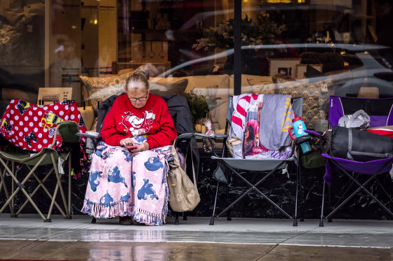 A woman looks at her phone on Colorado Boulevard on Dec. 31, 2025 in Pasadena, Calif.