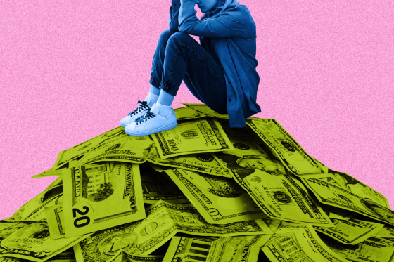 A woman (colorized in blue) who is crouched with her hands covering her face, seated atop a large pile of dollar bills (colorized in lime green), 20s, 10s, 5s and 1s can be seen in the mountainous pile, all against a pink background