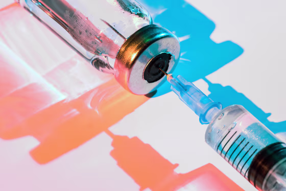 Glass bottle with vaccine and syringe for injection.