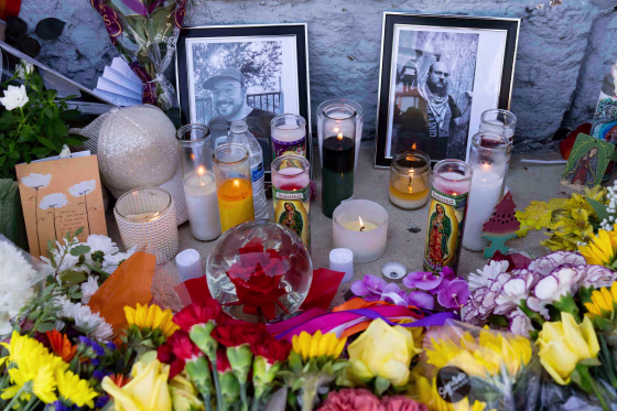 A memorial with two photographs, candles and flowers sits outside Venture-N Bar in Tucson.