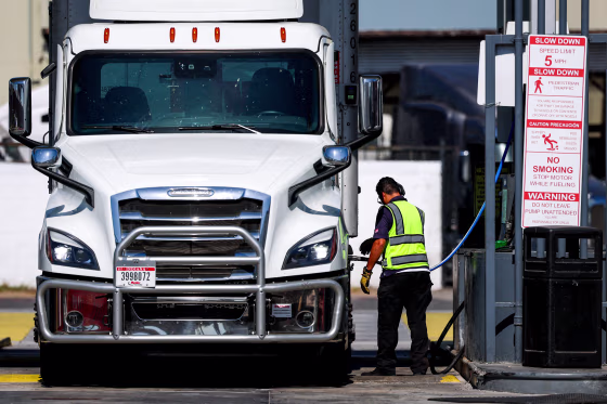 A truck driver refuels with diesel.