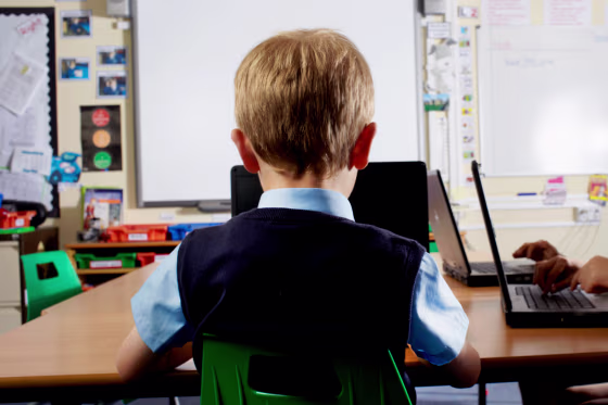 Young student in classroom using laptop 