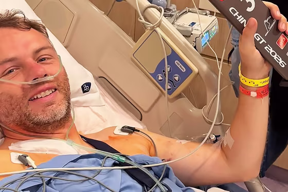 Image: Ollie Millroy lying in a hospital bed, wearing a nasal cannula.