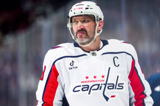 Alexander Ovechkin looks off while standing in the skating rink in full hockey uniform and a helmet
