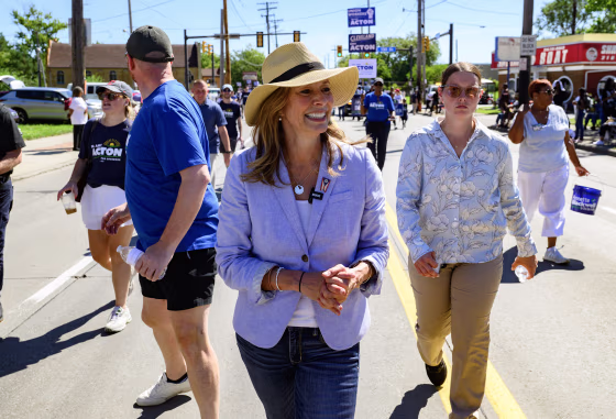 Amy Acton walking in a parade flanked by staffers.