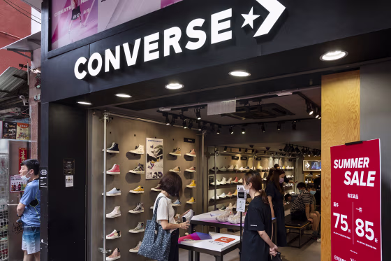 Pedestrians walk past American shoe brand company Converse