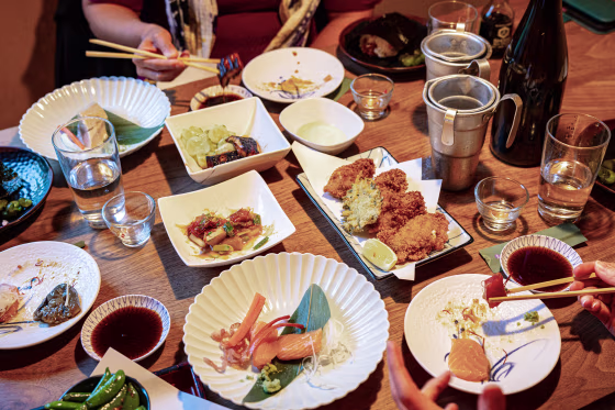 A top-down view of a crowded dining table at a Japanese restaurant.