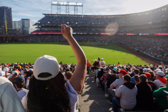 A woman cheers from the stands during a major league baseball game.