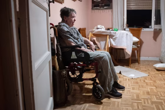 Maricarmen seated in a wheelchair inside of a room in her apartment