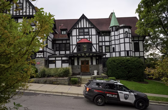 Cornell University police car passing by a fraternity house.