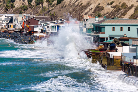 Powerful swells from Hurricane Polo, combined with a high tide, crash over protective boulders and seawalls