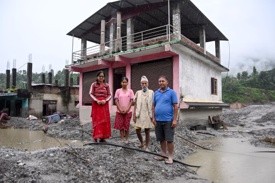 Residents of Nepal's Nuwakot district in front of their damaged shop.