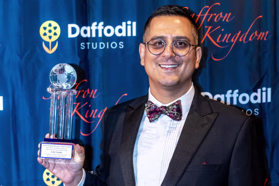 Arfat Sheikh holding an award.