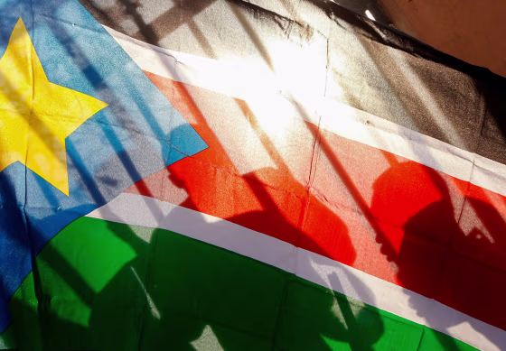 Silhouettes through a South Sudanese flag.