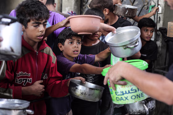 Image: Hot meals distributed to Palestinians in central Gaza's Nuseirat camp