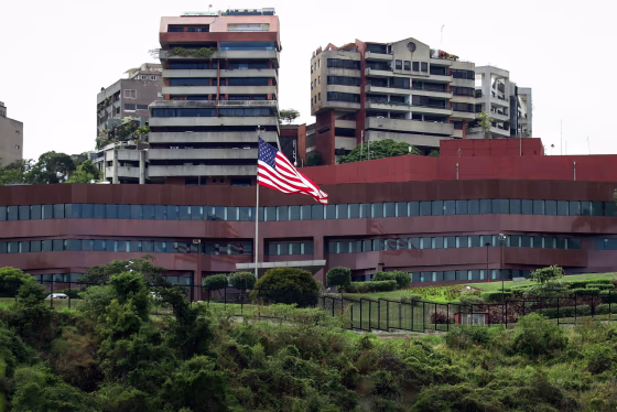 An American flag flies on a pole in front of the U.S. embassy building in Caracas