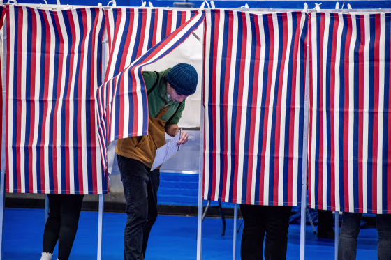 A person exits a voting booth after filling out their ballot.