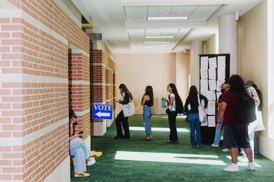 Voters wait in line to cast their ballots at a polling location on the first day of early voting for the midterm election in Texas