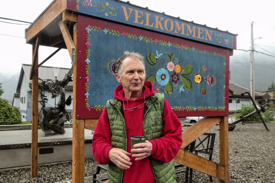 Dan J. Sullivan standing out doors holding a green mug.
