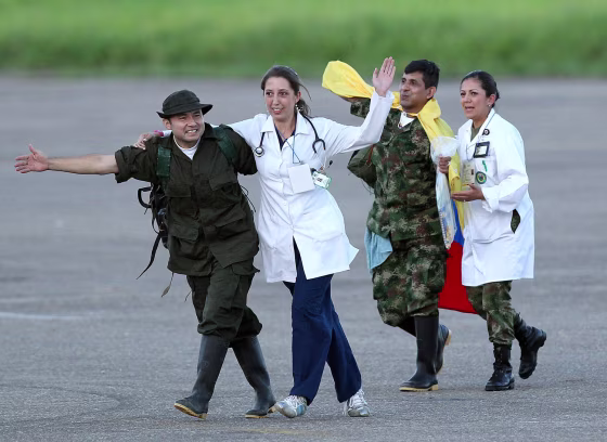 Colombian police sergeant Cesar Augusto Lasso Monzalve (L) and army sergeant Luis Alfredo Moreno (2-R) wave after being released by the Revolutionary Armed Forces of Colombia and landing with a humanitarian commision at the airport of Villavicencio, Colombia.