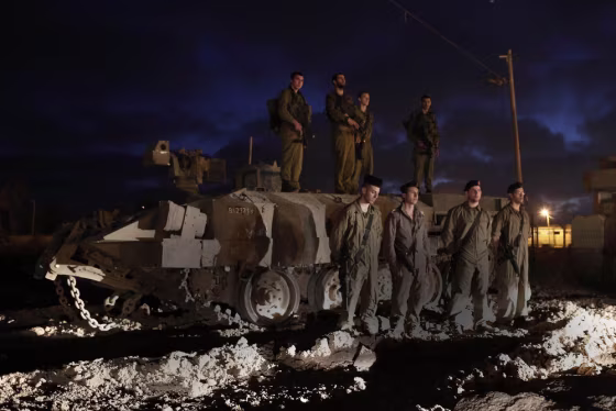Israeli soldiers stand still as a siren marks the annual Memorial Day for fallen Israeli soldiers, near the Israel border with the Gaza Strip, on April 24, 2012.