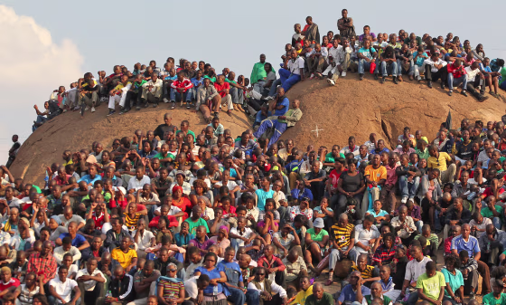 Mourners at a memorial service at the Lonmin Platinum Mine near Rustenburg, South Africa, Aug. 23, crowd onto the