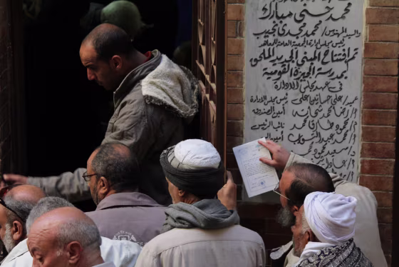 A government official checks voter ID cards outside a polling station near Cairo, Egypt, on Saturday.