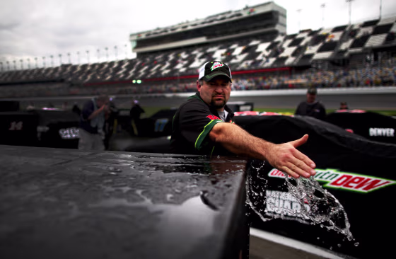 DAYTONA BEACH, FL - FEBRUARY 26:  A member of the #88 Diet Mountain Dew/National Guard Chevrolet crew wipes water from pit equipment during a rain delay for the NASCAR Sprint Cup Series Daytona 500 at Daytona International Speedway on February 26, 2012 in Daytona Beach, Florida.  (Photo by Tom Pennington/Getty Images for NASCAR)