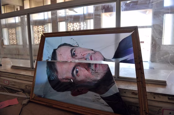 A broken picture of former Syrian president Hafez al-Assad, Bashar al-Assad's father, is seen at the Bab Al-Hawa border gate after clashes between Syrian rebels and the Syrian army on July 20, 2012.