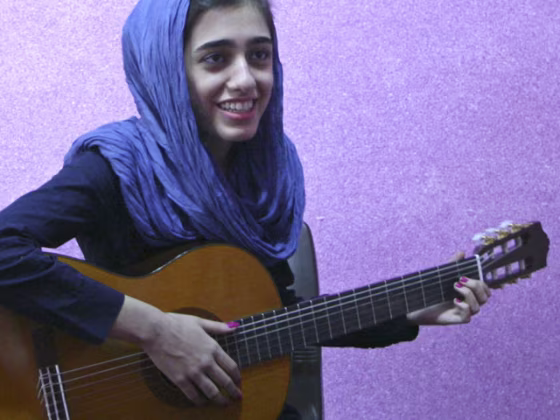 In this Thursday, Nov. 3, 2011 photo, Ghazaleh Miramini, left, practices guitar with her music teacher Amir Salami at a music school in Tehran, Iran. In the 1980s, Iran's music almost vanished. Music schools went into full recession, police or militias stopped cars to check what passengers were listening to and broke tapes playing pre-revolutionary singers, and clerical institutions even banned music as un-Islamic. But Iran's social life has dramatically changed a decade later, with a landslide victory of former President Mohammad Khatami with relaxing some of rigid restrictions on cultural and social activities, including bans on music bands, but Iran has tightened censorship of books, films, and music since President Mahmoud Ahmadinejad came to power. (AP Photo)