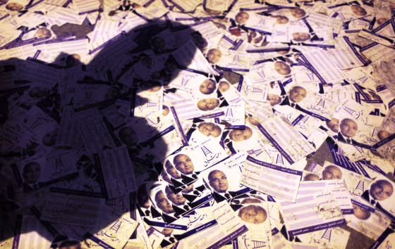 An Egyptian supporter walks on scattered electoral flyers with pictures of presidential runoff candidate Ahmed Shafiq in front of his ransacked campaign headquarters, in Cairo, Egypt.