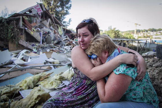 Tatyana Samokhval, left, daughter of local resident Sergei Khlystov, embraces her crying mother Valentina Khlystova in front of their partially demolished house in the Black Sea city of Sochi, Russia. The workers arrived at Sergei Khlystov's gate on a Friday evening to bulldoze his home and clear a path for sewage pipes to the Olympic village being built in the Russian city of Sochi. Khlystov and his 33-year-old son-in-law, Maxim Samokhval, at first tried to block the bulldozers but then stood aside and watched as the two-storey house was destroyed. The earthmovers ended Khlystov's battle to stay in his house, one of the last razed in the Mirny neighbourhood to make way for the Winter Olympics in 2014. Picture taken Sept. 19.
