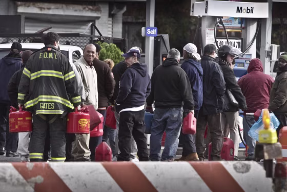 A fireman joins a gas line to get fuel for firehouse generators on Manhattan's lower east side. Lines were shorter Tuesday, but many stations remained...